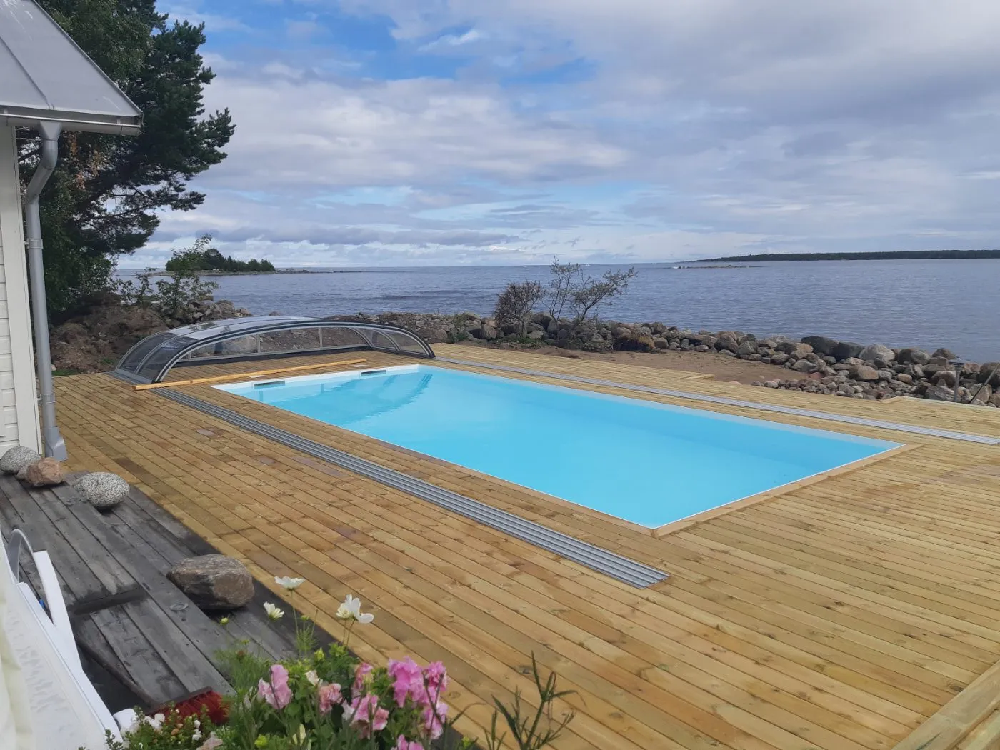 Pool med havsutsikt och trädäck